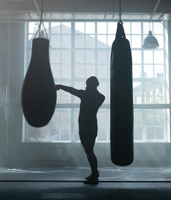 Man performing a controlled strength exercise in a dark gym with emerald light accents.